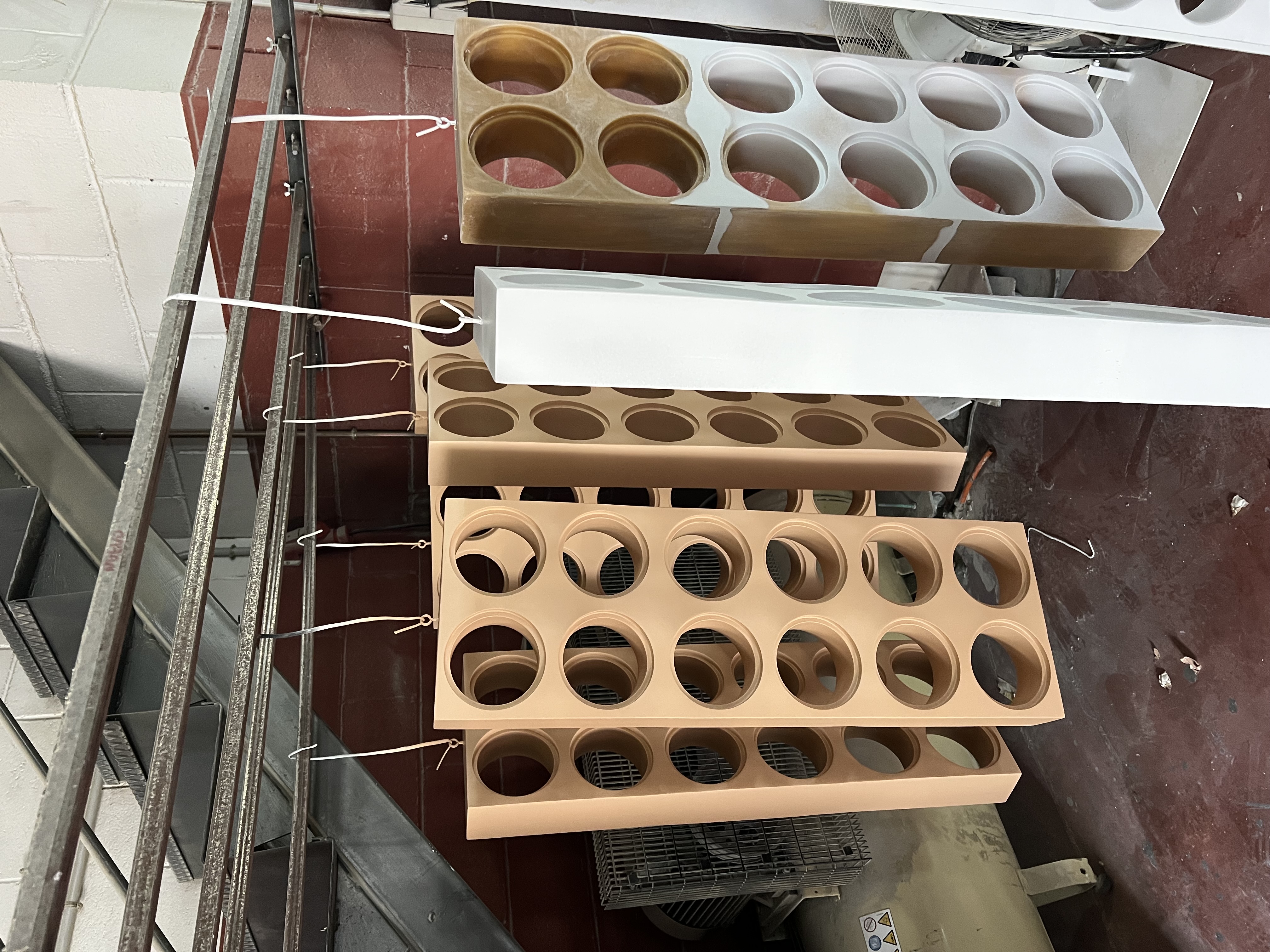 3D printed components with cutouts hanging in workshop