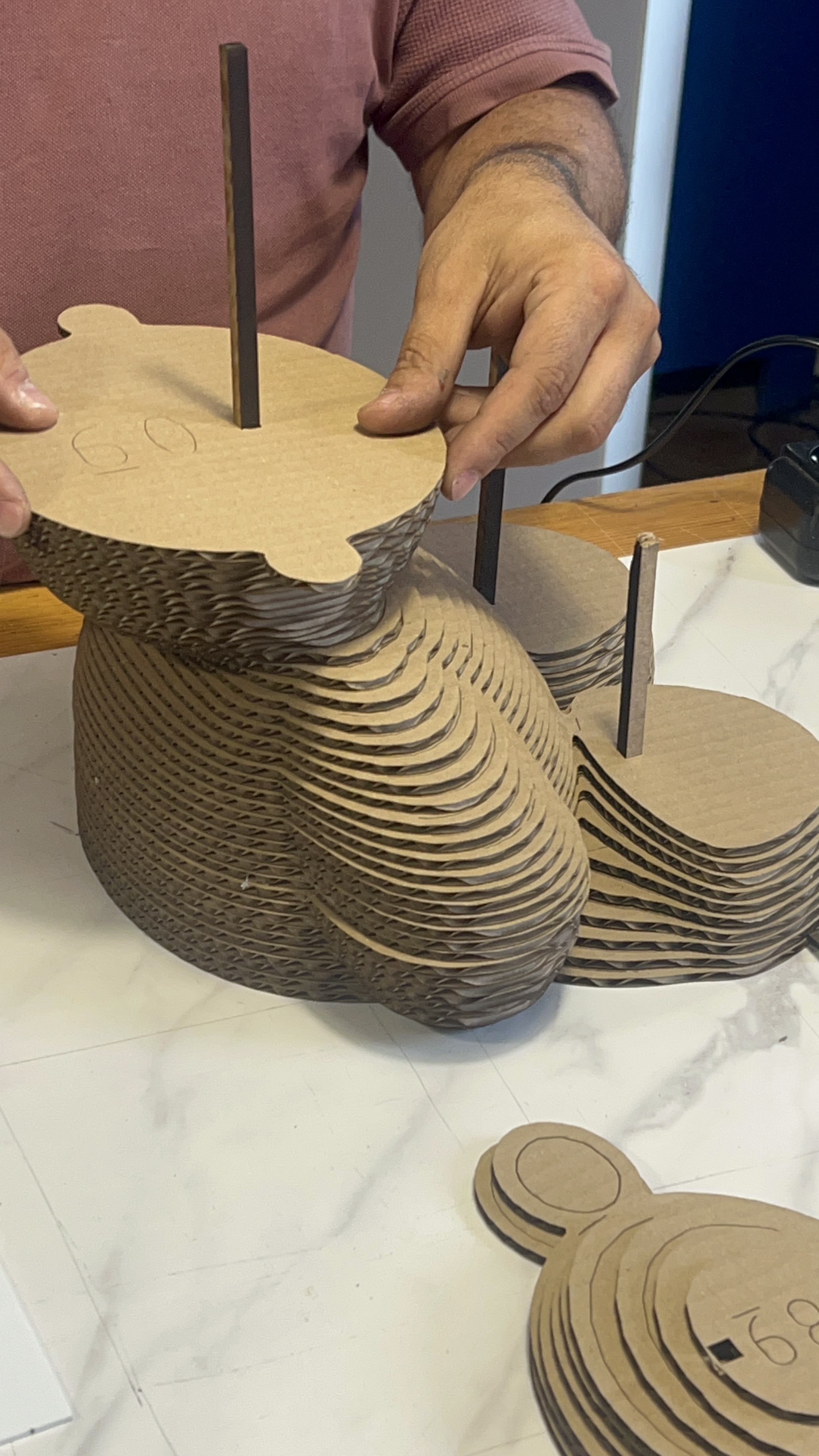 Craftsman assembling layered cardboard prototype